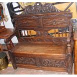 A Victorian carved oak hall seat with hinged lid -