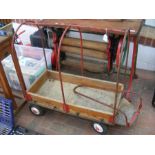 A vintage pull along child's wooden wagon with metal roll cage