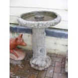 A moulded tree trunk bird bath