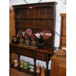 An antique oak dresser with plate rack over and th
