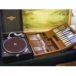 A canteen of cutlery and a picnic gramophone