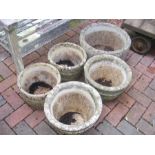 Five concrete garden planters of varying size