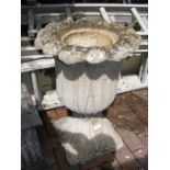 A tulip shaped garden urn on plinth