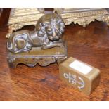 A cast metal lion paperweight and one other