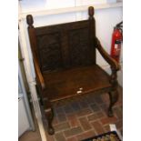 A carved oak hall seat on cabriole supports