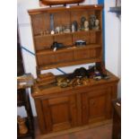 An antique pine dresser with cupboards below