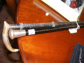 A silver topped walking cane and one other