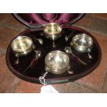 A cased set of four silver table salts with spoons