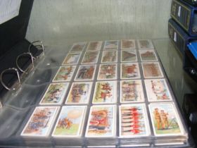 A large album containing collectable 1900-1920s cigarette card sets, including Players 1910 Army Lif