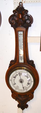 A Victorian oak barometer/thermometer in carved su
