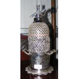 An antique soda syphon in silver plated stand