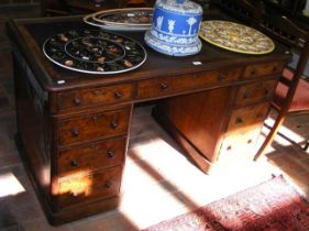 An antique walnut pedestal desk with nine drawers