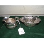 A silver cream jug together with pierced basket