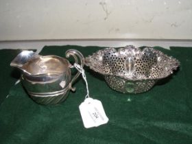 A silver cream jug together with pierced basket