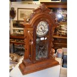 An antique wooden cased mantel clock with striking movement