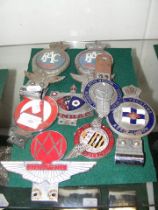 A selection of early car badges including Aston Ma