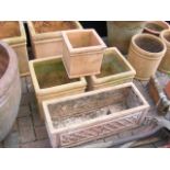 Three square terracotta plant pots and a rectangul