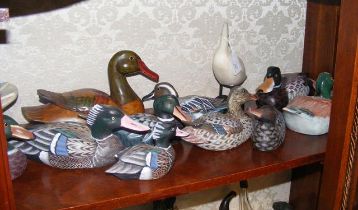 A collection of ornamental wooden ducks and birds