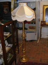 A decorative gilt standard lamp with fabric shade