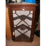 A mahogany corner cabinet with glazed swing door -
