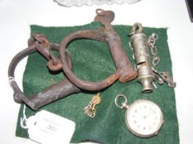 A pair of old cast metal handcuffs, police whistle