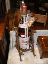 A vintage bottle of Brandy in wrought iron stand