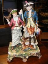 A Continental figural group of couple with dogs -