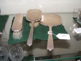 A three piece silver backed dressing table set