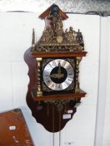 A reproduction wall clock with exposed bell to top