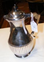 A silver water jug with fluted design