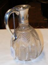 A cut glass claret jug with silver mount with ball