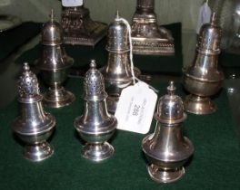 Six various sized silver pepperettes