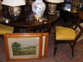 An antique oak gate-leg table on turned supports