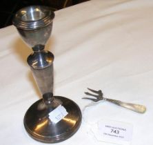 A silver candlestick together with a pickle fork