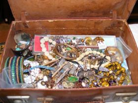 A small vintage suitcase filled with costume jewel