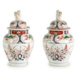 A PAIR OF EARLY 18TH CENTURY JAPANESE IMARI SHOULDERED VASES AND COVERS