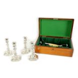 A GEORGE V OAK CASED SET OF FOUR GEORGE I STYLE SILVER CANDLESTICKS