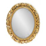 A LARGE OVAL 19TH CENTURY FLORENTINE CARVED GILT WOOD FRAMED MIRROR