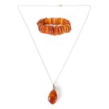 A LARGE SILVER MOUNTED AMBER PENDENT AND BRACELET