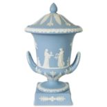 A WEDGWOOD MEDIUM BLUE JASPER WARE TWO-HANDLED URN SHAPED VASE AND COVER ON PEDESTAL BASE