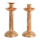 A PAIR OF ARTS AND CRAFTS NEWLYN SCHOOL COPPER CANDLESTICKS