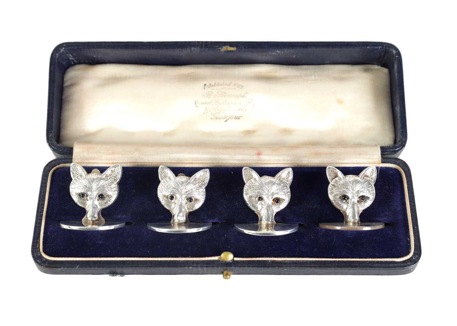 A CASED SET OF FOUR FOX HEAD SILVER MENU HOLDERS