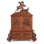 A 19TH CENTURY CARVED WALNUT BLACK FOREST CIGAR CABINET