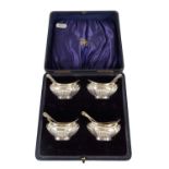 AN EDWARD VII CASED SET OF FOUR SILVER OPEN SALTS AND SPOONS