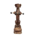 A 19TH CENTURY BLACK FOREST CARVED WALNUT STICK STAND FORMED AS A SEATED DOG