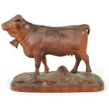 A 19TH CENTURY SWISS CARVED LINDEN WOOD COW IN THE MANNER OF JOHANN HUGGLER