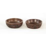 A PAIR OF AFRICAN LIGNUM VITAE RELIEF CARVED CIRCULAR BOWLS