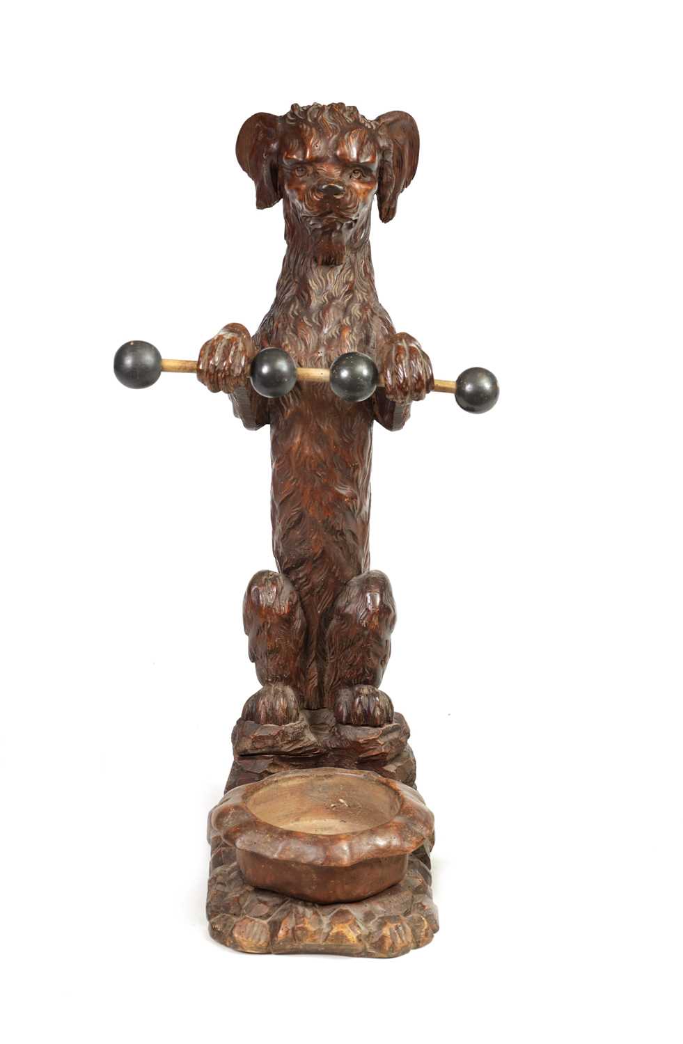 A 19TH-CENTURY BLACK FOREST CARVED WALNUT STICK STAND FORMED AS A BEGGING DOG