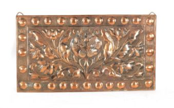 AN ARTS AND CRAFTS PLANISHED COPPER AND EMBOSSED WALL PLAQUE