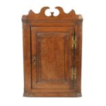 A RARE EARLY 18TH CENTURY BURR OAK PANELLED CORNER CUPBOARD OF SMALL SIZE